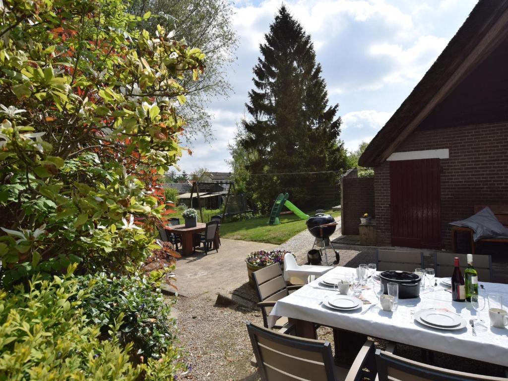 a patio with a table and chairs and a tree at Quaint Farmhouse near River in Oosterwijk in Leerdam
