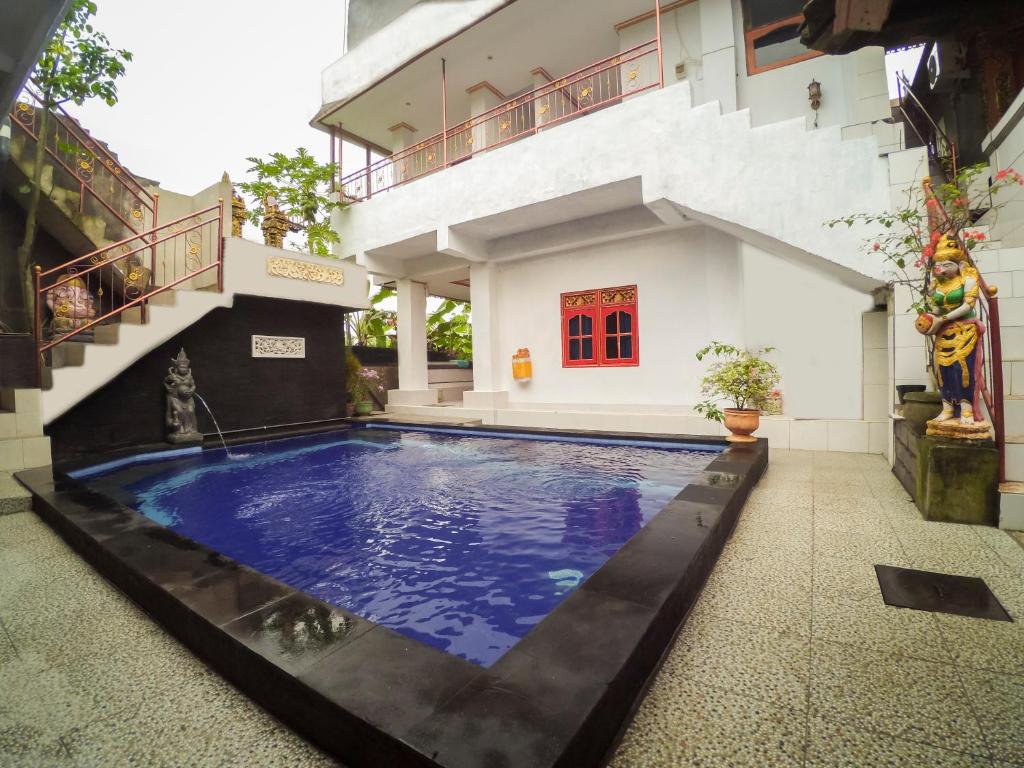 a swimming pool in front of a house at Kabera Bungalow Ubud in Ubud