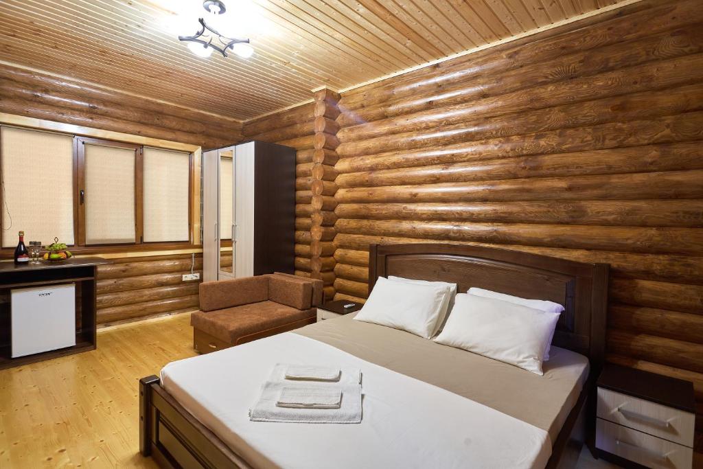 1 dormitorio con 1 cama y 1 silla en Krisna Mini-hotel, en Gudauta