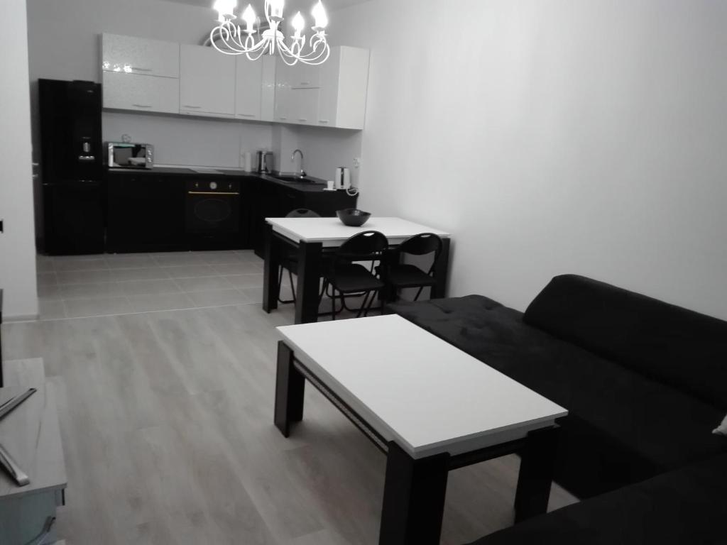 a living room with a couch and tables and a kitchen at Апартамент Дарко in Pomorie