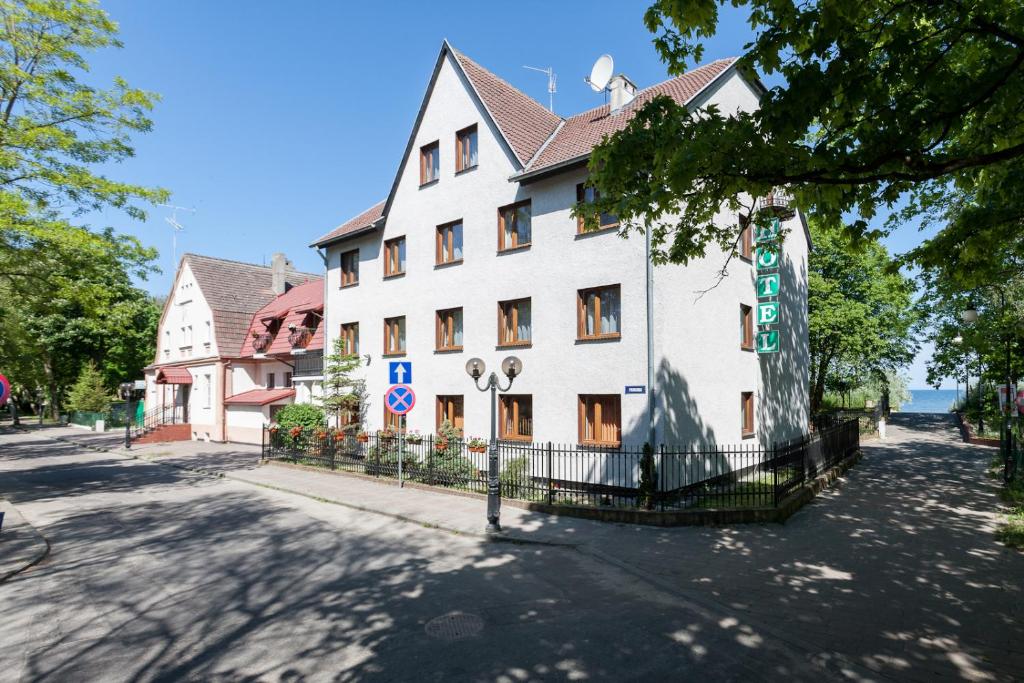 a large white building on the side of a street at Ośrodek Wypoczynkowy AS PIK dawniej Hotel AS PIK in Niechorze