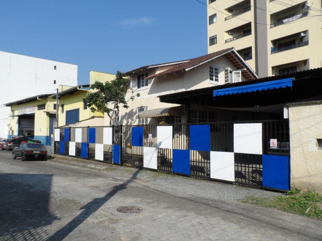 une clôture noire et blanche devant un bâtiment dans l'établissement Austria Hostel & Pousada, à Blumenau