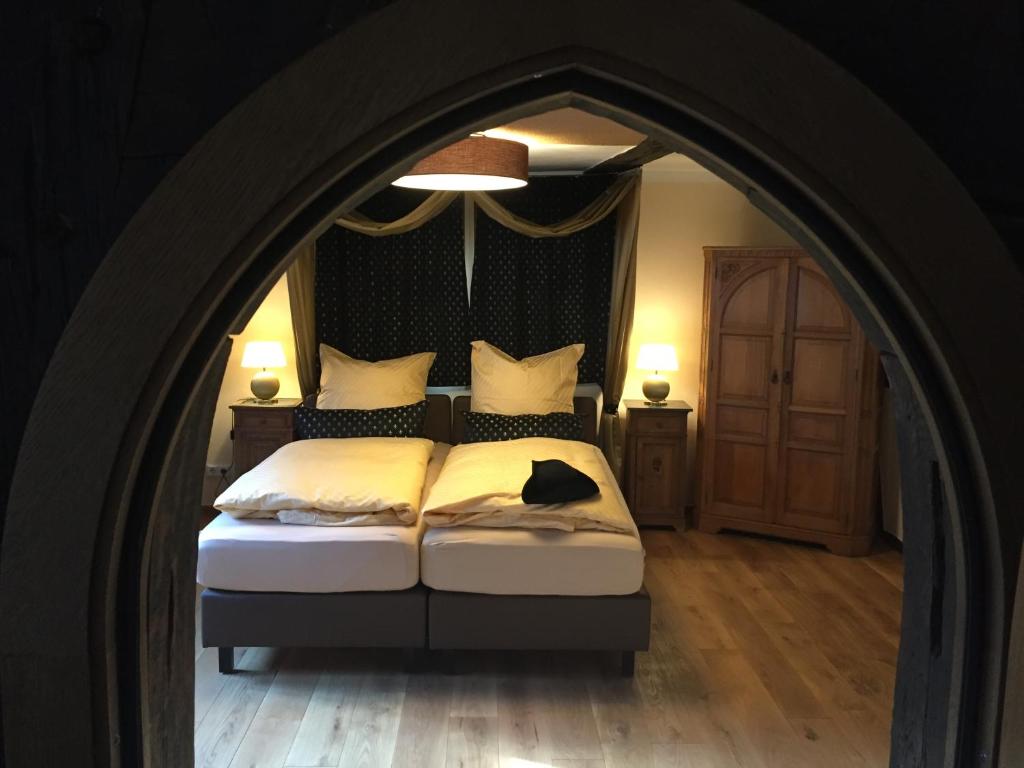 a bedroom with a large bed with a black headboard at McMüller's Kemenate Fulda in Fulda