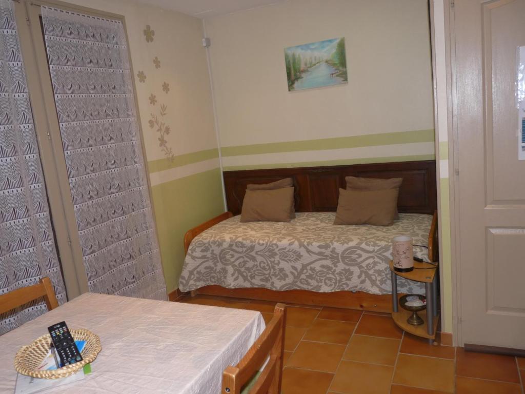 Habitación pequeña con 1 cama y 2 mesas en Chambres d'Hôtes Le Baou, en Annot