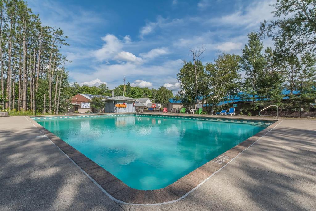 - une piscine d'eau bleue dans l'établissement Jolly Roger Inn & Resort, à Otter Lake