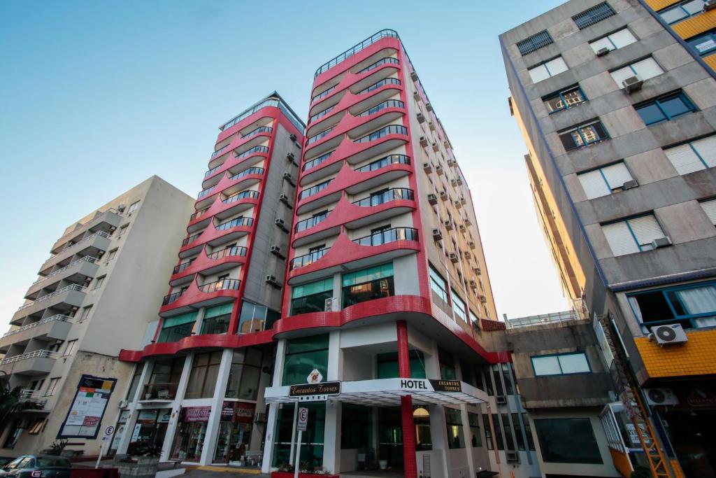 wysoki czerwony budynek przed dwoma wysokimi budynkami w obiekcie Life Hotel Torres w mieście Torres