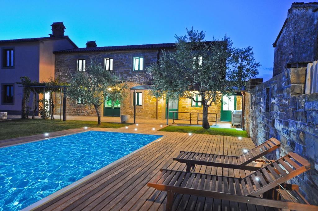 a swimming pool with two chairs and a house at Gorgeous Istrian Villa in Marezige