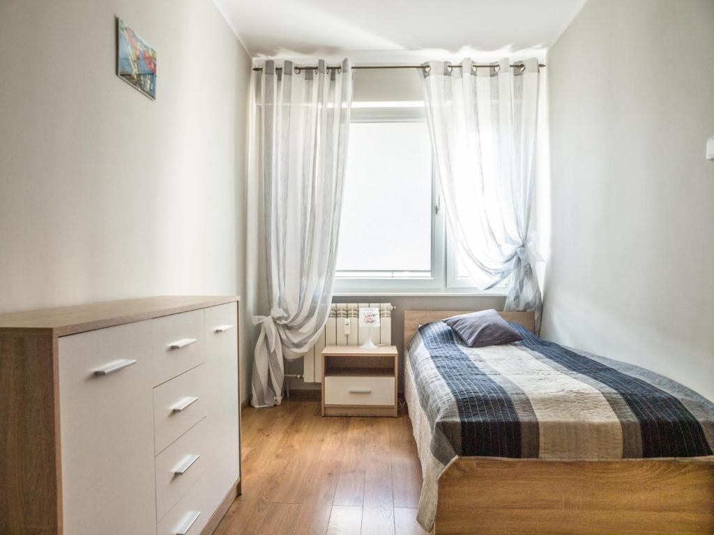 um quarto com uma cama e uma janela em Apartament Plaza48 em Gdańsk