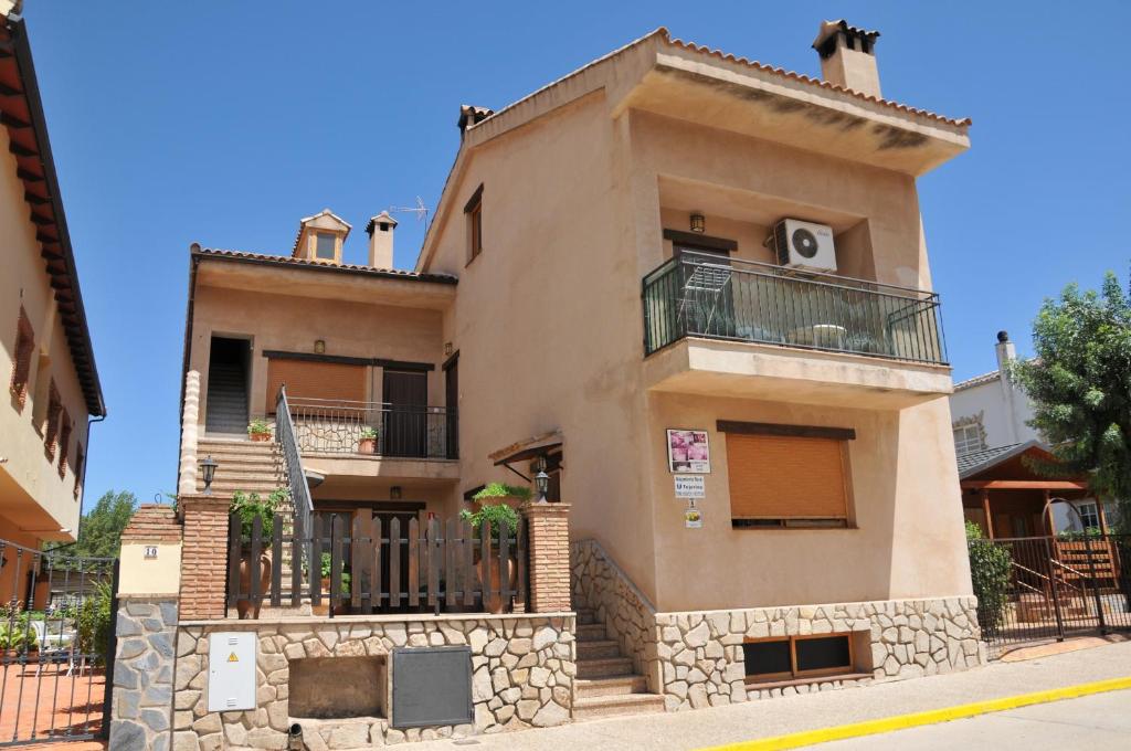 Une grande maison avec balcon est située dans une rue. dans l'établissement Alojamientos Rural Tejerina, à Arroyo Frío