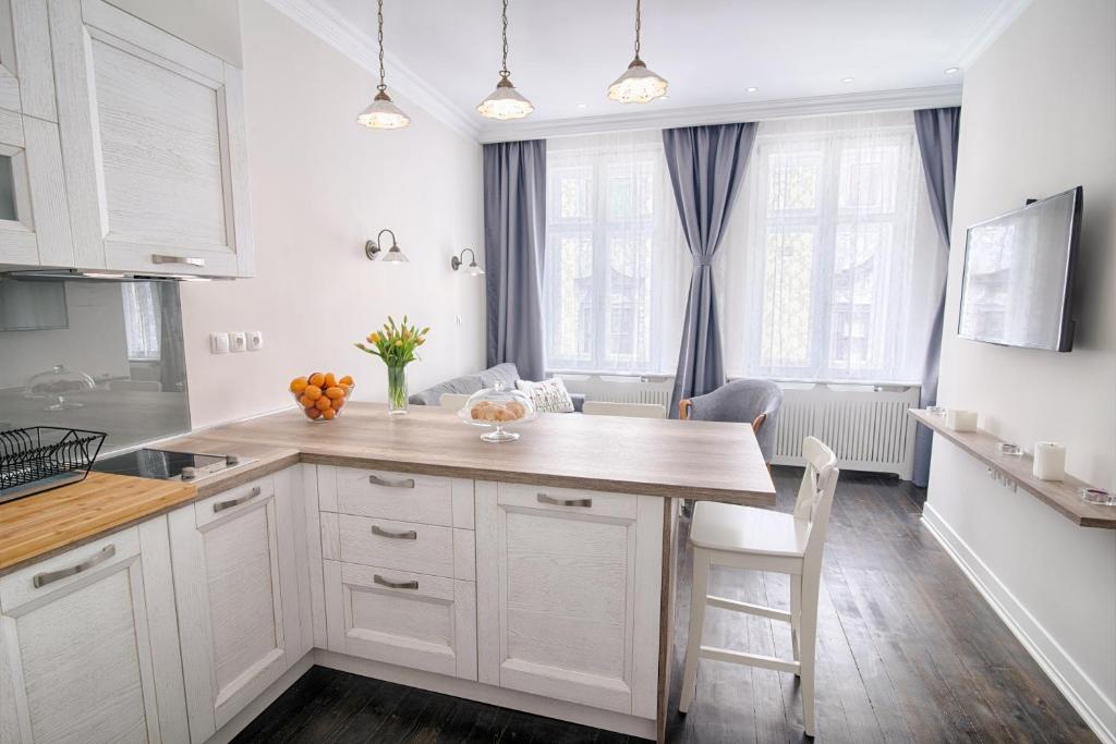 a kitchen with white cabinets and a large island at Sweet 16 Studio in Ljubljana