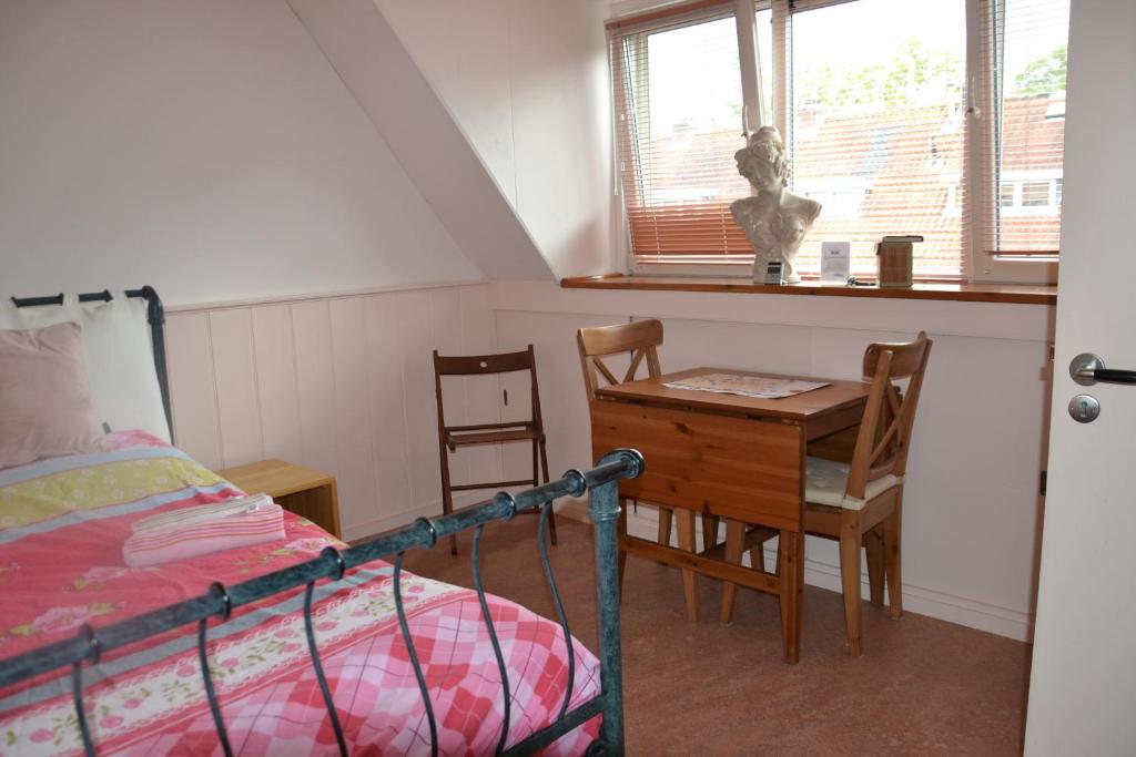 a bedroom with a bed and a table and chairs at B&B MACBED CHECKIN-TIME 1700-1800 or request before you book in Alkmaar