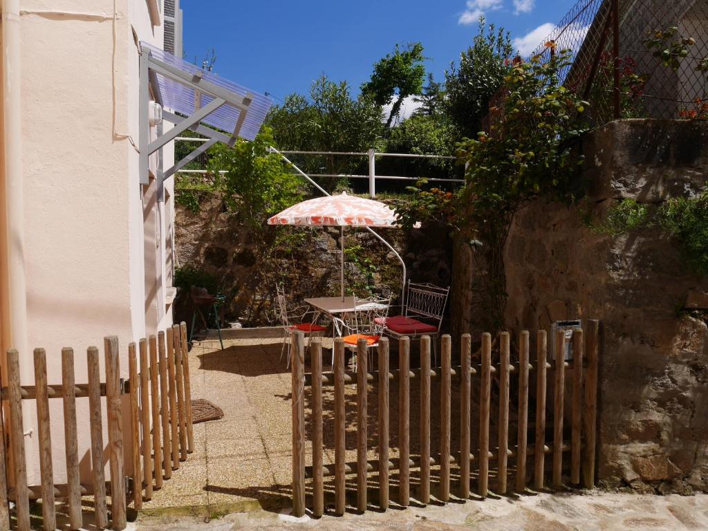 valla de madera con mesa y sombrilla en A Cittadella, en Vico