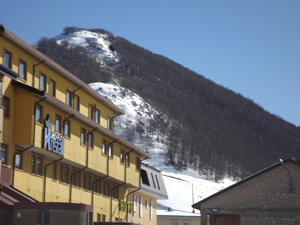 um edifício em frente a uma montanha coberta de neve em Hotel Kristall em San Massimo