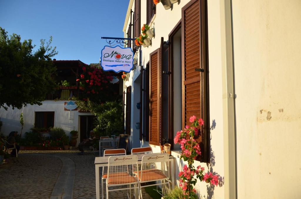a group of chairs sitting outside of a building at Nova Citrus Otel in Siğacık