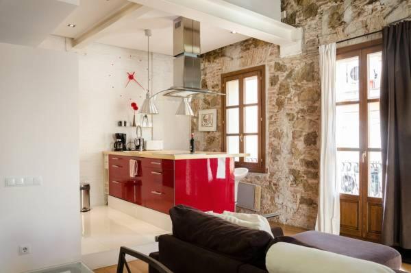 a living room with a couch and a kitchen at Loft en Gràcia ArchsenseApartments in Barcelona