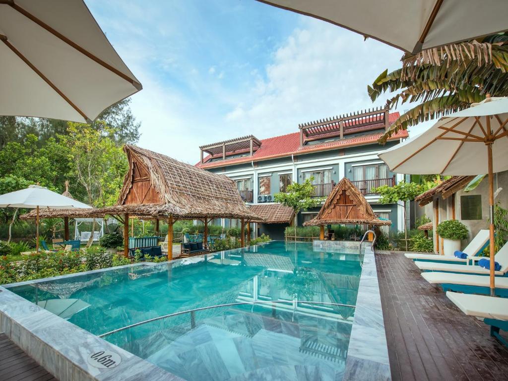 a resort with a swimming pool and a building at AIRA Boutique Hoi An Hotel & Villa in Hoi An