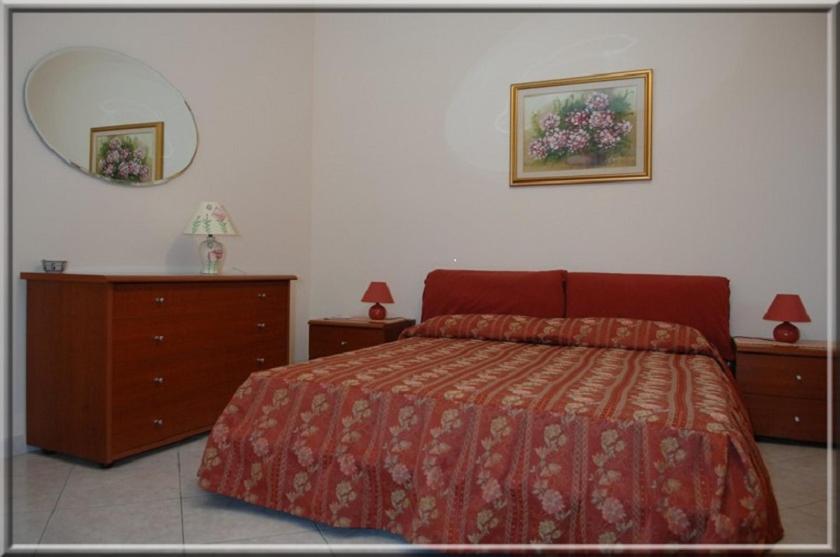 奧里斯塔諾的住宿－B&B Ida，一间卧室配有一张床、梳妆台和镜子