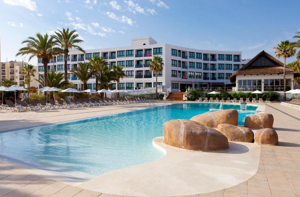 una piscina con un hotel en el fondo en Marvell Club Hotel & Apartments, en Bahía de San Antonio