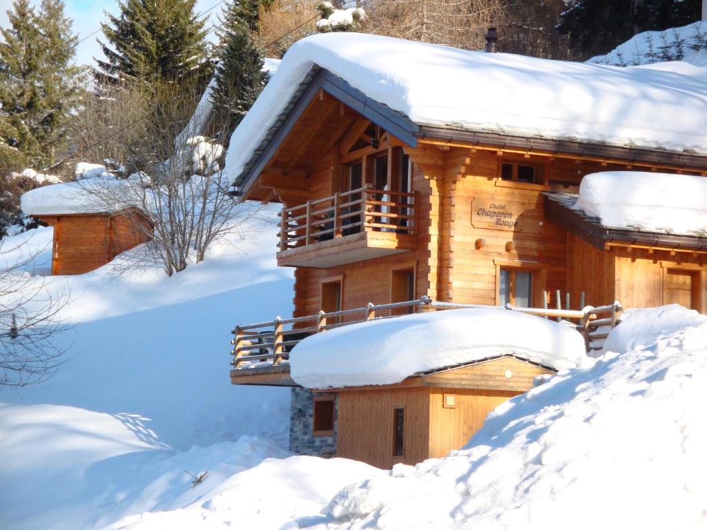 una cabaña de madera cubierta de nieve en Chalet Chaperon Rouge en Nendaz