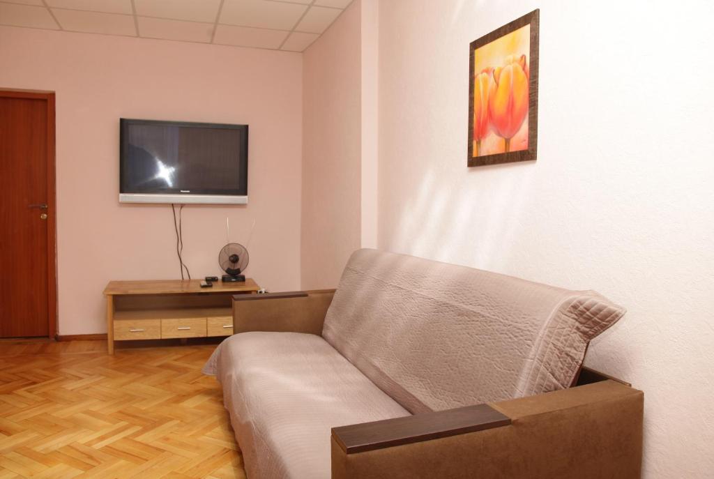 uma sala de estar com um sofá e uma televisão de ecrã plano em Apartments on Moskovskaja em Dnipro
