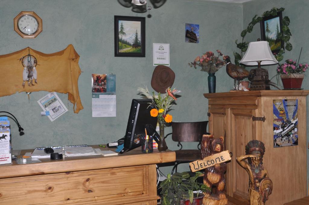 Zimmer mit einem Schreibtisch und einer Uhr an der Wand in der Unterkunft Long Holiday Motel in Gunnison