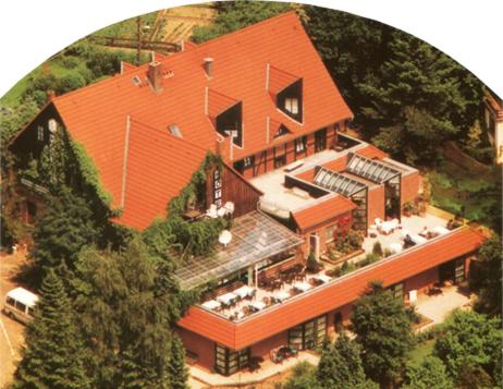eine Luftansicht eines großen Hauses mit orangefarbenem Dach in der Unterkunft Hotel Restaurant Landluft in Aerzen