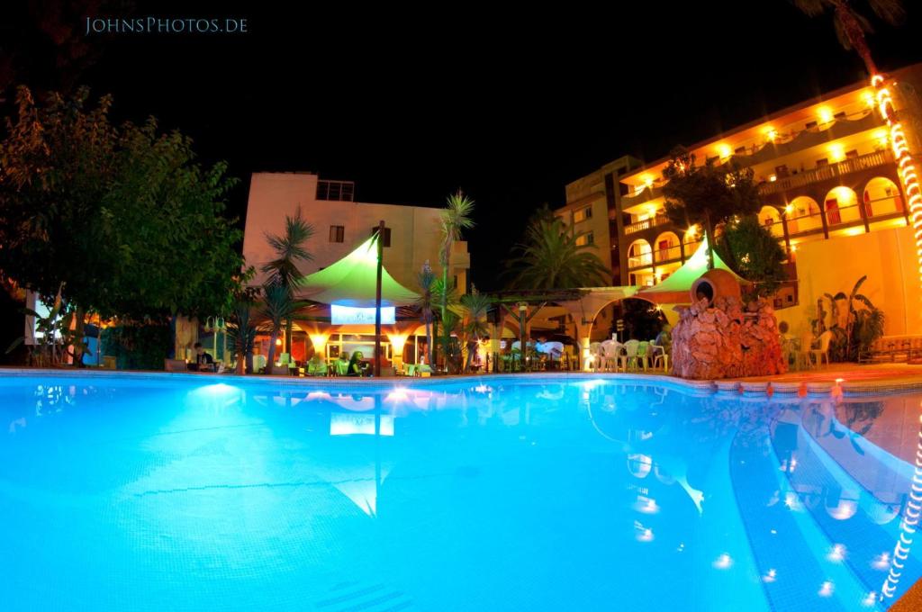 a large swimming pool in front of a building at night at Mini Golf Apartments in Canyamel
