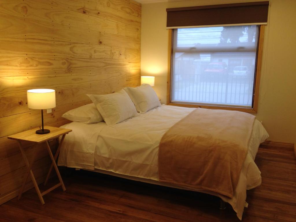 a bedroom with a large bed with a window at Canquen Patagonia in Punta Arenas