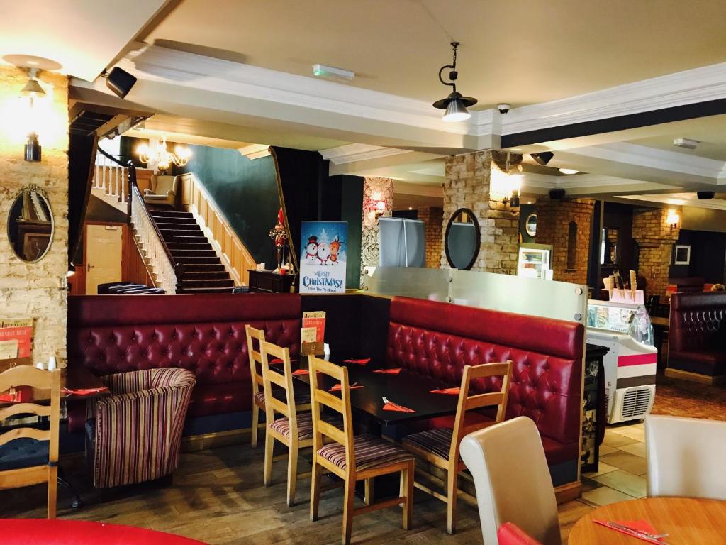 a restaurant with a table and chairs and stairs at The Portland in Ashington