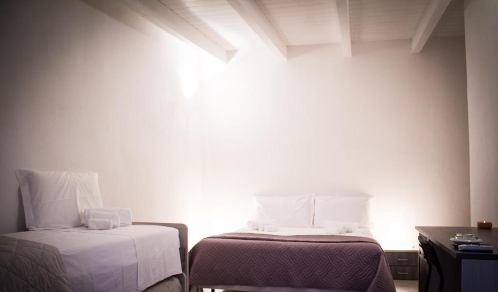 a small room with two beds and a table at Masseria D'Aprile in Castellaneta