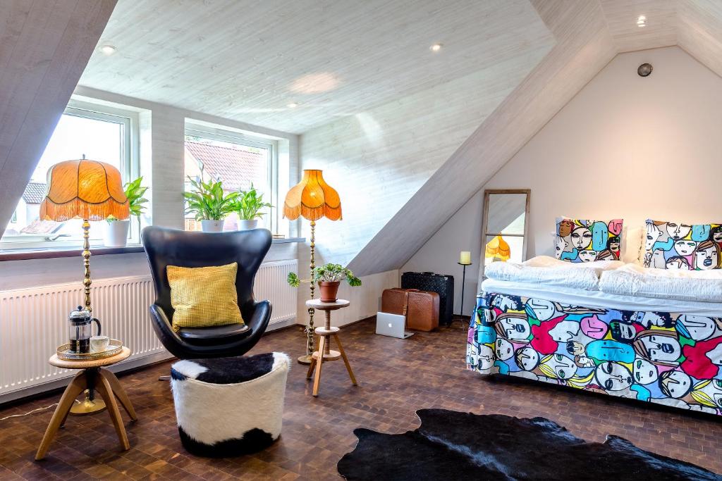 Sankt OlofにあるStudio på loftet i två planの屋根裏のベッドルーム(ベッド1台、椅子付)