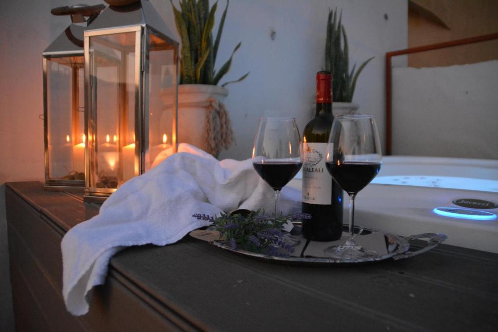 a table with two wine glasses and a bottle of wine at Ziolì in Noto