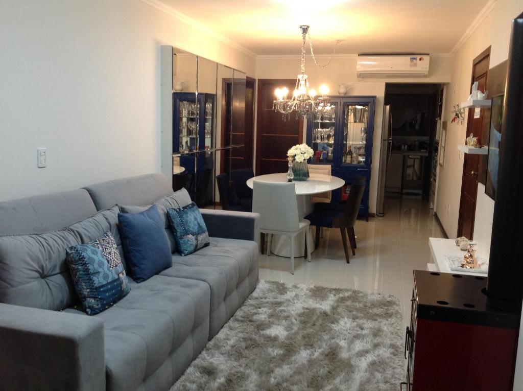 a living room with a couch and a dining room at Ednamar Apartmentos Gramado Siena in Gramado