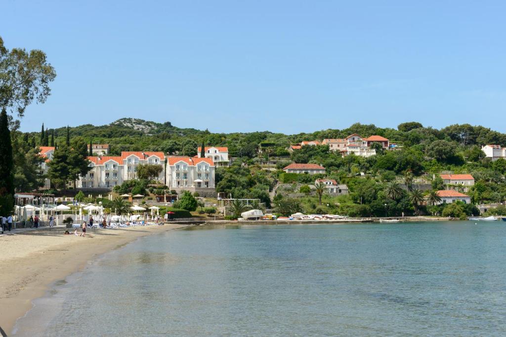 Blick auf einen Strand mit Häusern auf einem Hügel in der Unterkunft Oreb Dream Apartments in Koločep