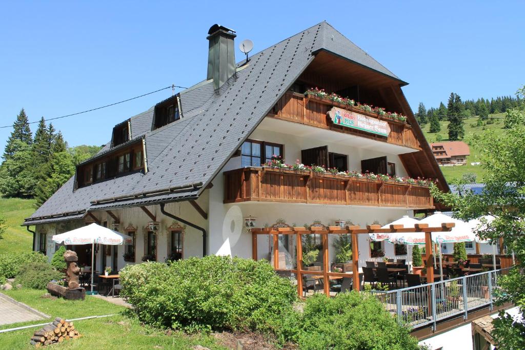 ein großes Haus mit Balkon mit Menschen darauf in der Unterkunft Hotel & Restaurant Grüner Baum - Die Grüne Oase Am Feldberg in Feldberg