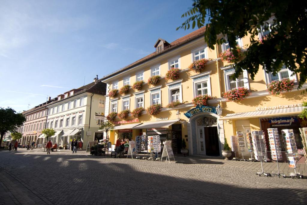 un edificio en una calle con gente caminando por la calle en Hotel Post Murnau, en Murnau am Staffelsee