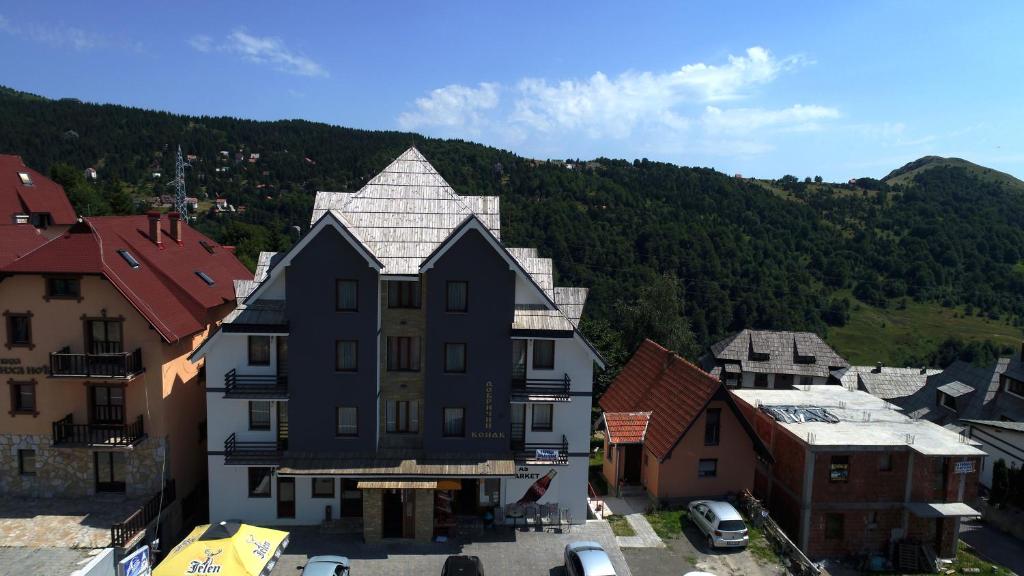 a building in a town with a mountain in the background at Dobricin Konak Apartments in Kopaonik