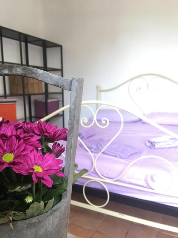 a chair with purple flowers sitting next to a bed at Pietrasanta in Pietrasanta