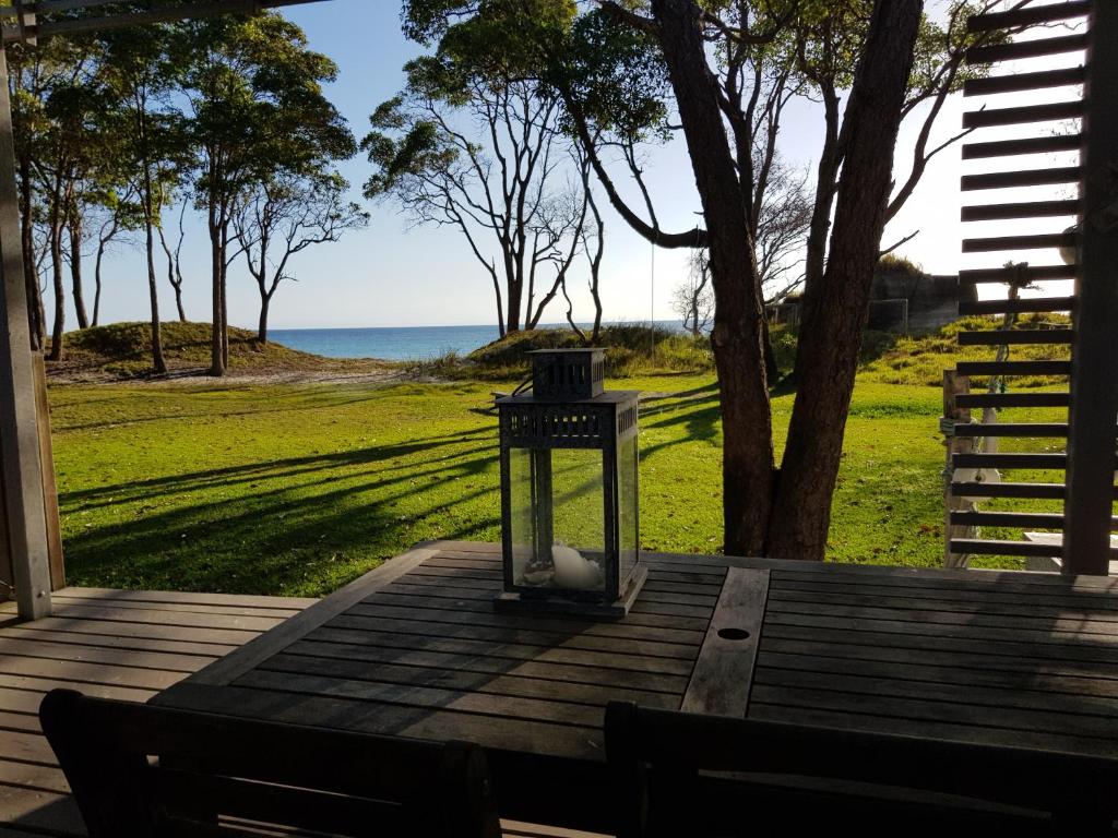 uma lanterna sentada num alpendre com vista para o oceano em The Jetty at Cowan Cowan em Cowan Cowan