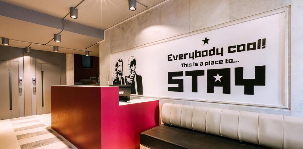 a lobby with a sign on the wall of a store at Stay Hybrid Hostel in Thessaloniki