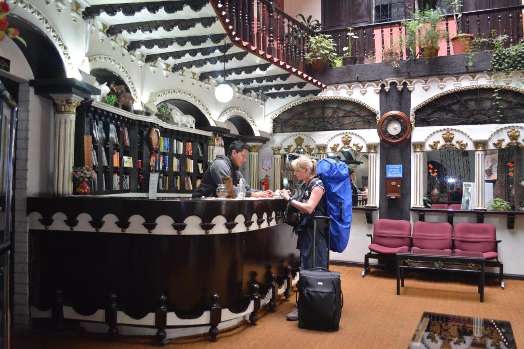 a woman standing at a bar in a book store at Hostal Juana de Arco in Quito