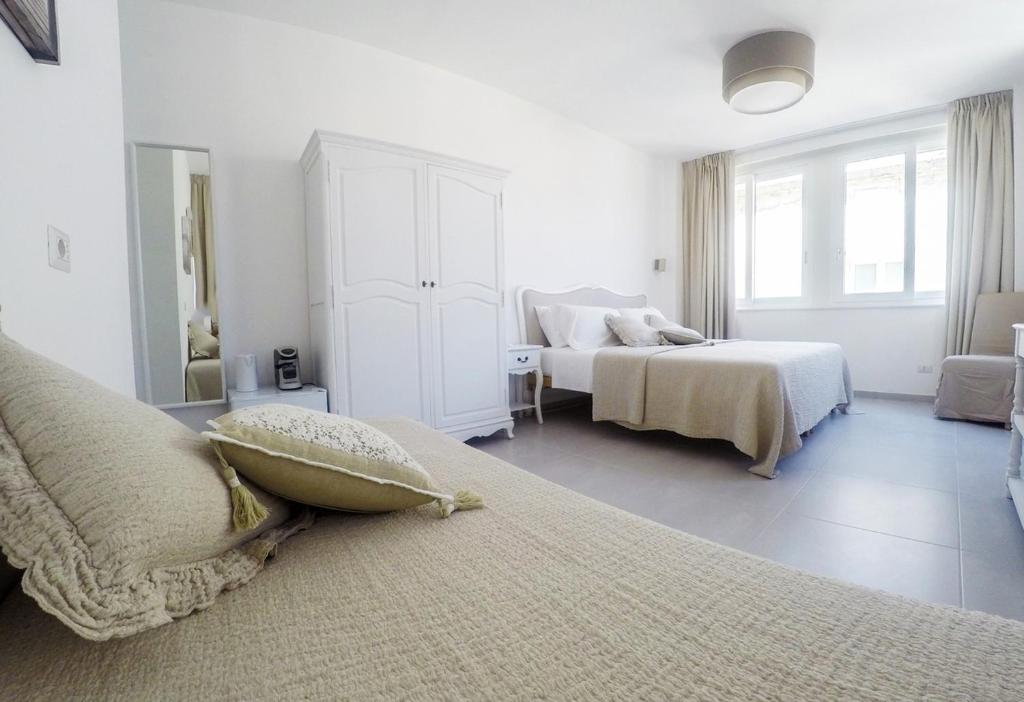 レッチェにあるCentral Suites Lecceの白いベッドルーム(ベッド2台、窓付)