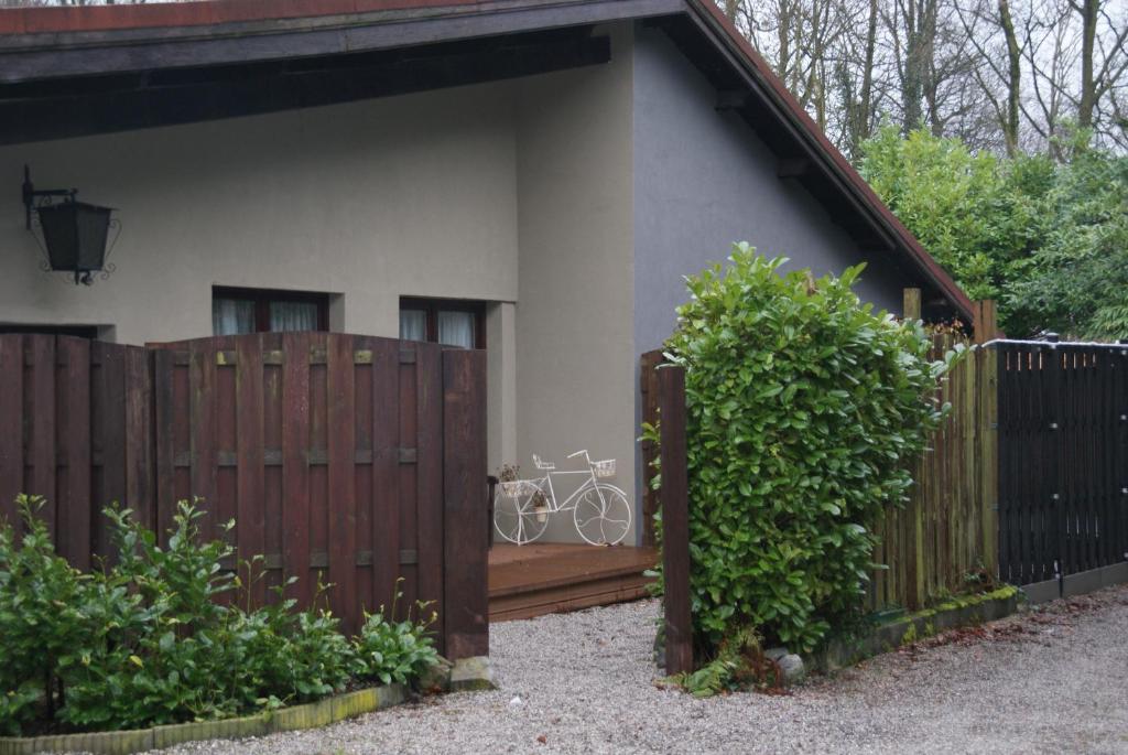 una casa con una valla de madera con una bicicleta en Studios Jps, en Les Flaches