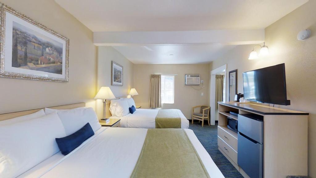 Habitación de hotel con 2 camas y TV de pantalla plana. en Napa Discovery Inn, en Napa