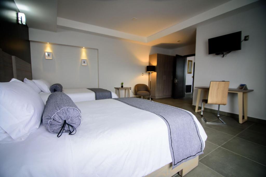 Postel nebo postele na pokoji v ubytování Maria Ines Hotel Suite