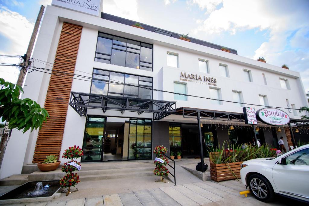 a white building with a car parked in front of it at Maria Ines Hotel Suite in Oaxaca City