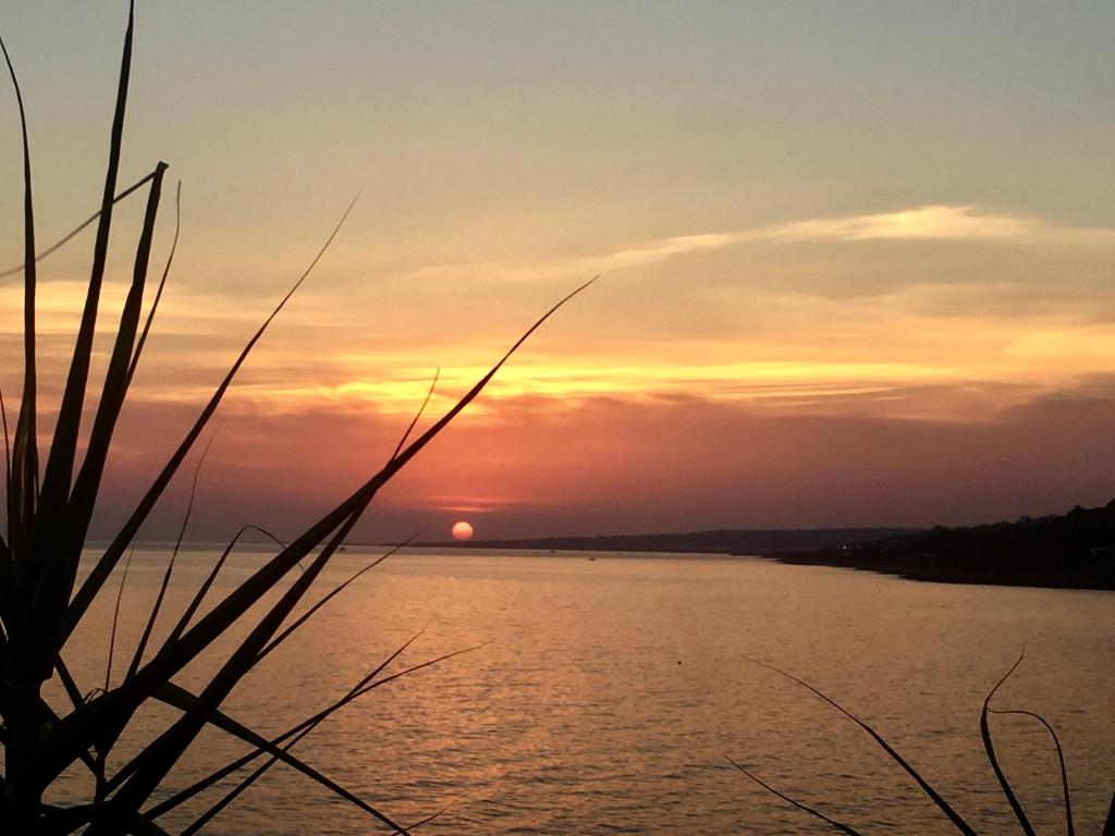 una puesta de sol sobre un gran cuerpo de agua en Guest House - La Sirena Salentina, en Patù