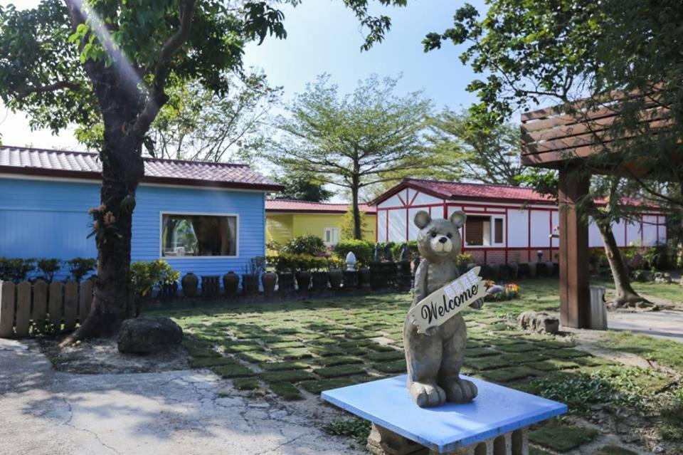 een standbeeld van een beer met een bord in een tuin bij Zhang Yi Ya Zhu Homestay in Baihe