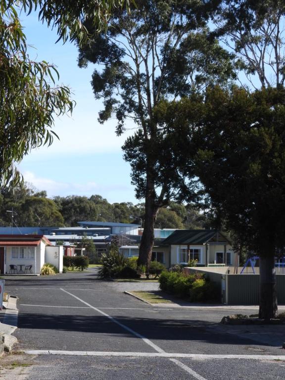 a parking lot with trees and buildings in the background at Moomba Holiday and Caravan Park in Port Sorell