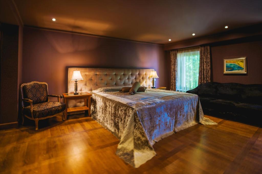 - une chambre avec un lit, une chaise et un canapé dans l'établissement Ventura Boutique Hotel, à Varna